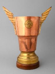 TROPHÉE EN CUIVRE ET LAITON SUR SOCLE BOIS AVEC UN MÉDAILLON FIGURANT UN JOUEUR DE BOULES