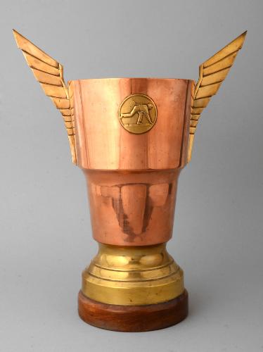 TROPHÉE EN CUIVRE ET LAITON SUR SOCLE BOIS AVEC UN MÉDAILLON FIGURANT UN JOUEUR DE BOULES